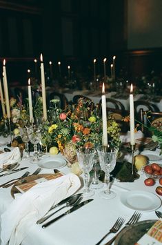 the table is set with candles, plates and silverware for an elegant dinner party