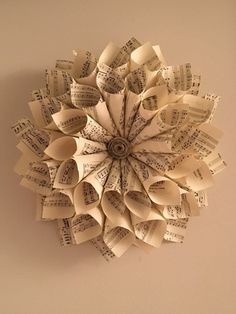 an origami flower made out of old sheet music notes is hanging on the wall