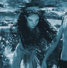 a man and woman holding hands under water