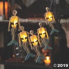 skeletons are hanging from strings with candles in the shape of fish