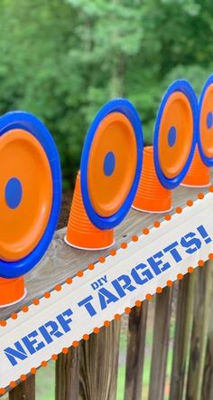 orange and blue frisbees sitting on top of a wooden fence