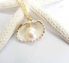 Beautiful gold sea shell necklace made with a gold plated seashell charm with a gold filled chain and fresh water pearl. This necklace makes a unique gift for a beach lover or someone special in your life. The seashell is around 15- 20mm long. Each item is carefully packaged in a beautiful jewellery box ready as a gift. If you would like to add a personalized note with your order, just write a note at checkout and I will send a small card with your gift to the recipient. Please choose necklace l Ocean-inspired Pearl Charm Jewelry For Gifts, Ocean-inspired Pearl Charm Jewelry As Gift, Ocean-inspired Pearl Charm Jewelry Gift, Handmade Gold Shell Strand, Pearl Charm Strand Jewelry Gift, Handmade Gold Strand Shell, Pearl Charm Strand Jewelry As Gift, Gold Strand Jewelry For Gift, Elegant Gold Strand Jewelry