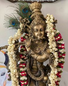 a golden statue with flowers around it