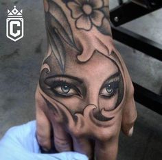 a woman's hand with an artistic tattoo design on the wrist and eyeliners