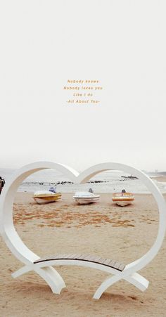 a heart shaped sculpture sitting on top of a sandy beach