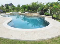 a swimming pool surrounded by lush green trees and shrubs in a backyard with stone steps leading up to it