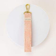 an orange and white piece of paper with a gold keychain attached to it