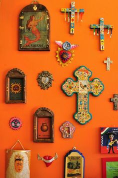 an orange wall covered in crosses and pictures