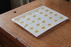 a white tray with yellow dots sitting on top of a wooden table