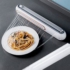 a plate of pasta with mushrooms on it next to a hairdryer and roller