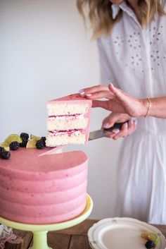 a woman cutting a cake with a knife