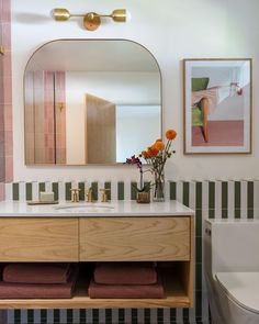 a bathroom with a sink, mirror and toilet in it's centerpieces