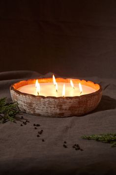 a bowl filled with candles sitting on top of a table