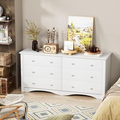 a white dresser sitting in a bedroom next to a bed