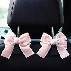 two pink bows on the back of a car seat