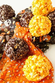 chocolate covered cookies and candy balls on an orange cloth with black dots around them, sitting on a white surface