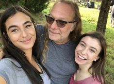 two girls and an older man posing for the camera