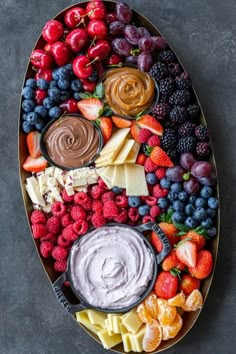 an oval platter filled with fruit and dips