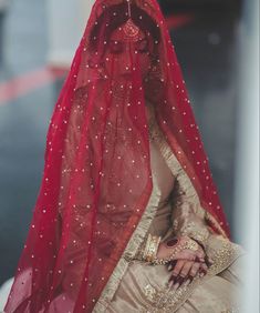 a woman wearing a red veil and sitting down