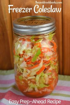 a mason jar filled with freezer coleslaw on top of a striped table cloth