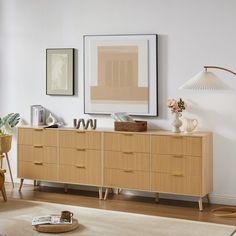 a living room with a dresser and pictures on the wall