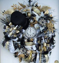 a wreath with a clock, hat and ribbons hanging on the front door to celebrate new year's eve