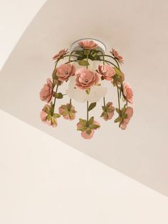 a ceiling light with pink flowers hanging from it