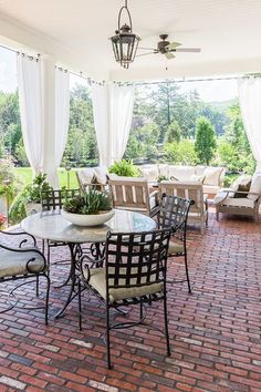 an outdoor dining area with chairs, tables and potted plants on the patio table