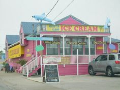 a pink ice cream shop sitting on the side of a road