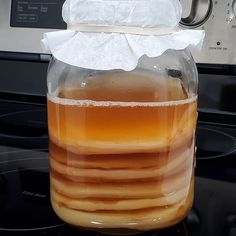 a jar filled with liquid sitting on top of a stove