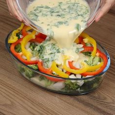 someone pouring dressing into a glass bowl filled with vegetables