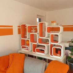 an orange and white living room with shelves on the wall, potted plants in vases