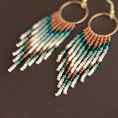 Embrace the spirit of bohemian flair with these captivating fringe beaded hoop earrings. Featuring a stunning interplay of turquoise and burnt orange beads, they cascade playfully from high-quality, lightweight hoops. Each meticulously handwoven bead adds to the unique and vibrant design, ensuring these earrings become cherished conversation starters. More than just an accessory, these earrings are testaments to artisan skill.  The intricate beadwork and high-quality materials elevate them beyon Turquoise Bohemian Beaded Fringe Earrings, Bohemian Turquoise Tassel Earrings With Beaded Fringe, Bohemian Hoop Earrings With Tiny Beads, Bohemian Fringe Dangle Hoop Earrings, Bohemian Dangle Fringe Hoop Earrings, Bohemian Chandelier Earrings With Fringe And Round Beads, Bohemian Dangle Jewelry With Beaded Fringe, Burnt Orange Accents, Hoop Earrings Diy