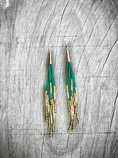 green and gold beaded earrings on wooden background