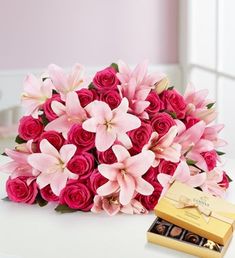 a bouquet of pink flowers and chocolates on a table