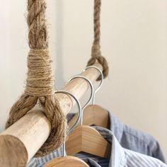 clothes hanging on wooden hangers with rope