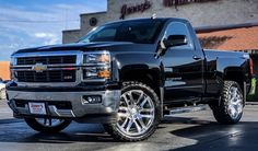 a black truck parked in front of a store