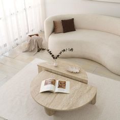 a living room with a couch, table and book on the coffee table in front of it