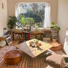 a living room filled with lots of furniture and books on top of a wooden table