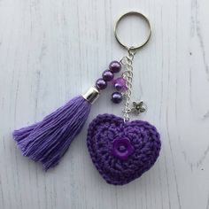 a crocheted heart keychain with tassels and beads