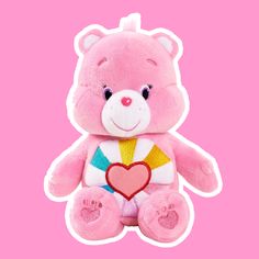 a pink teddy bear with a heart on it's chest, sitting against a white background