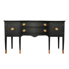 a black desk with gold handles and drawers