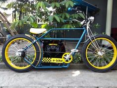 a blue and yellow bike parked next to a tree