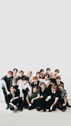 a group of young men posing for a photo in front of a white wall and floor