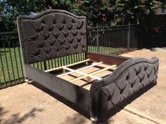 a black bed frame sitting on top of a sidewalk