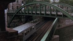 a train traveling over a bridge next to tall buildings