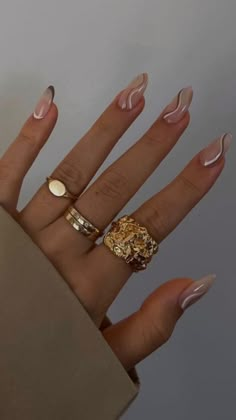 a woman's hand with two rings on it and some manicured nails in the background