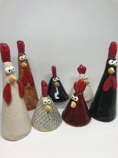 five ceramic roosters are lined up in a row