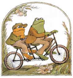 two frogs riding on the back of a bicycle