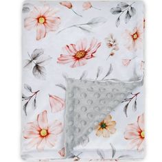 a white blanket with pink flowers and grey polka dots on the bottom, along with an orange flowered design